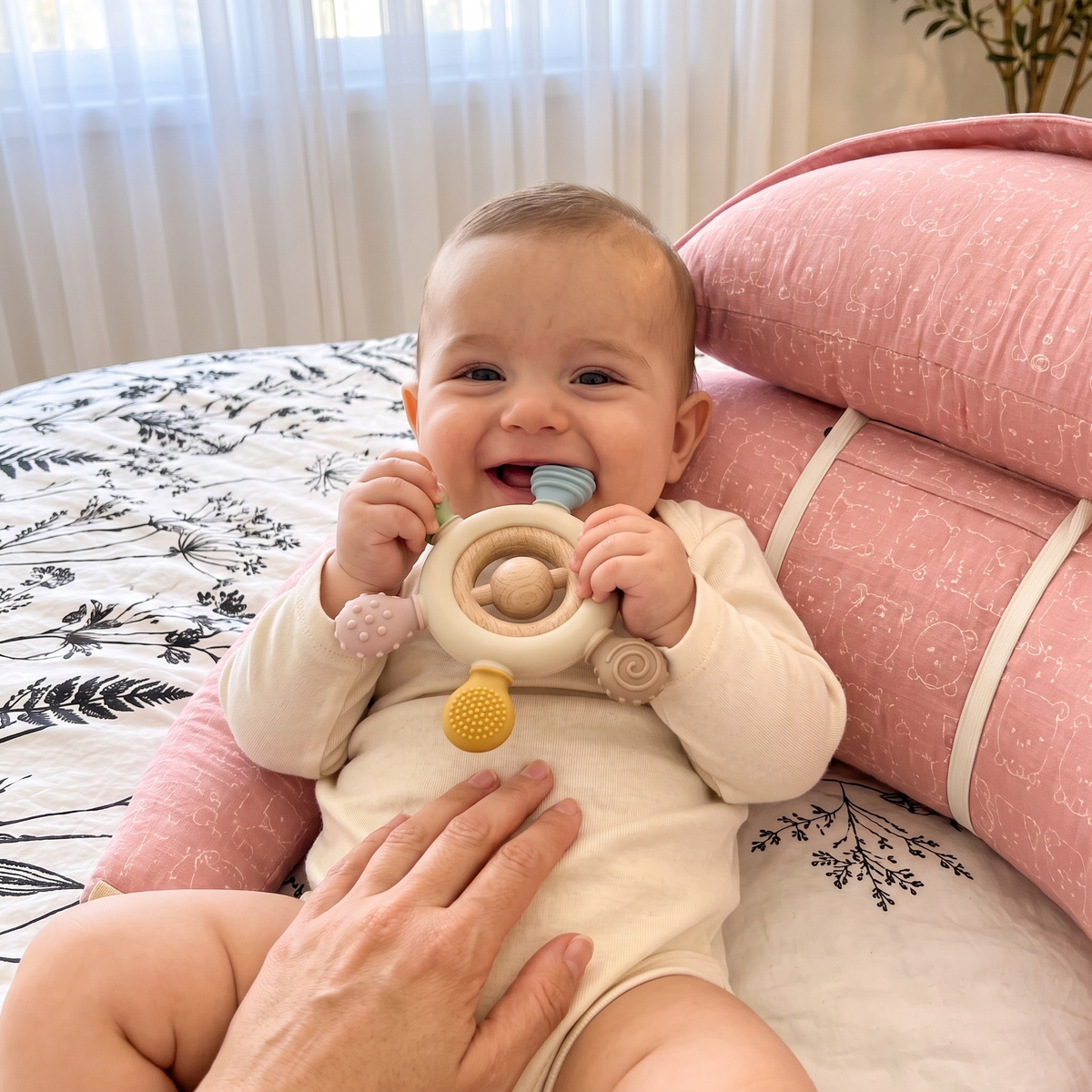 Yatakta bej dümen diş kaşıyıcı ile oynayan bebek
